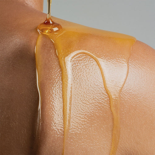 HERLOW body and post shave oil for women with a glistening golden texture on skin