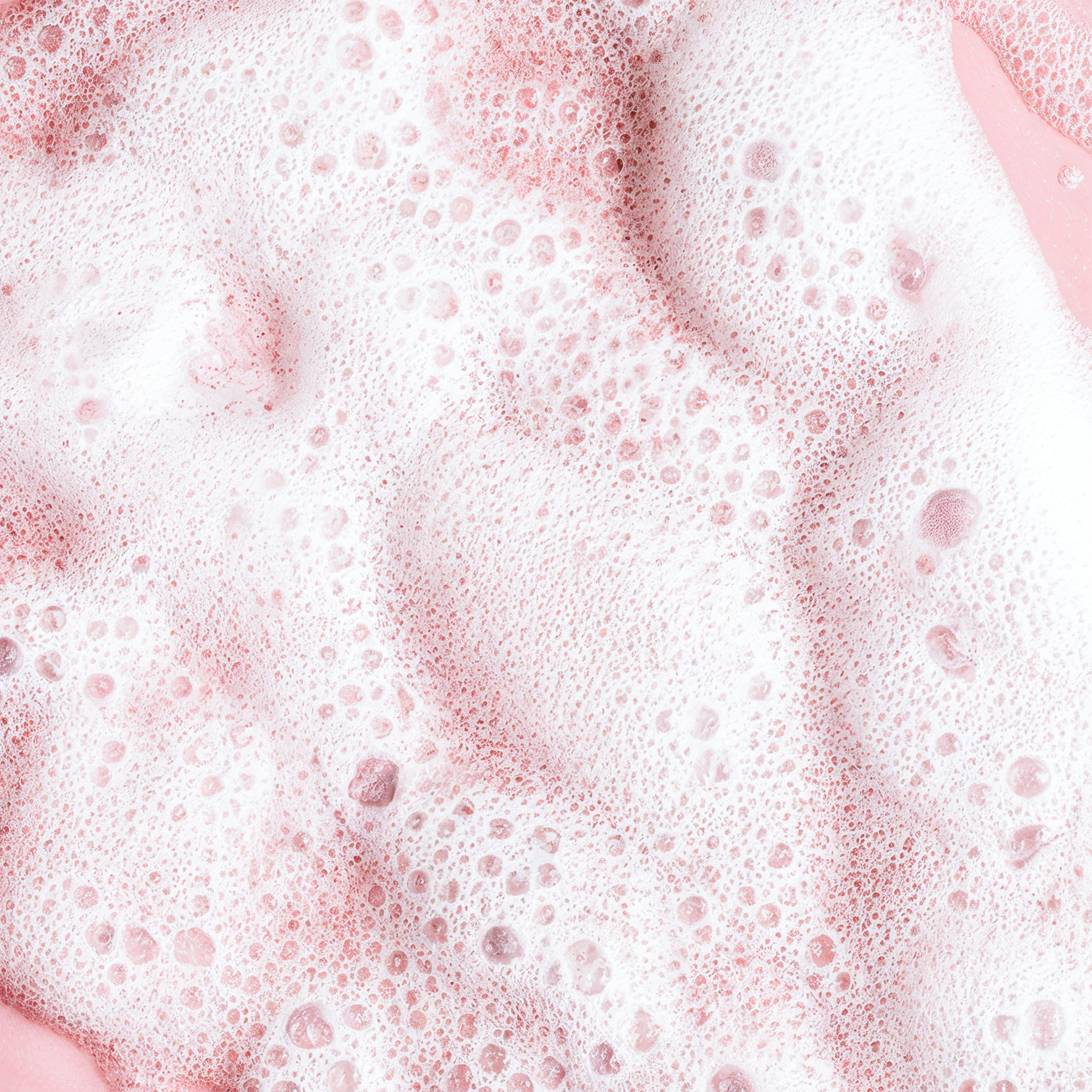Pink bubbles from HERLOW milky oil foaming cleanser showing its rich, frothy texture