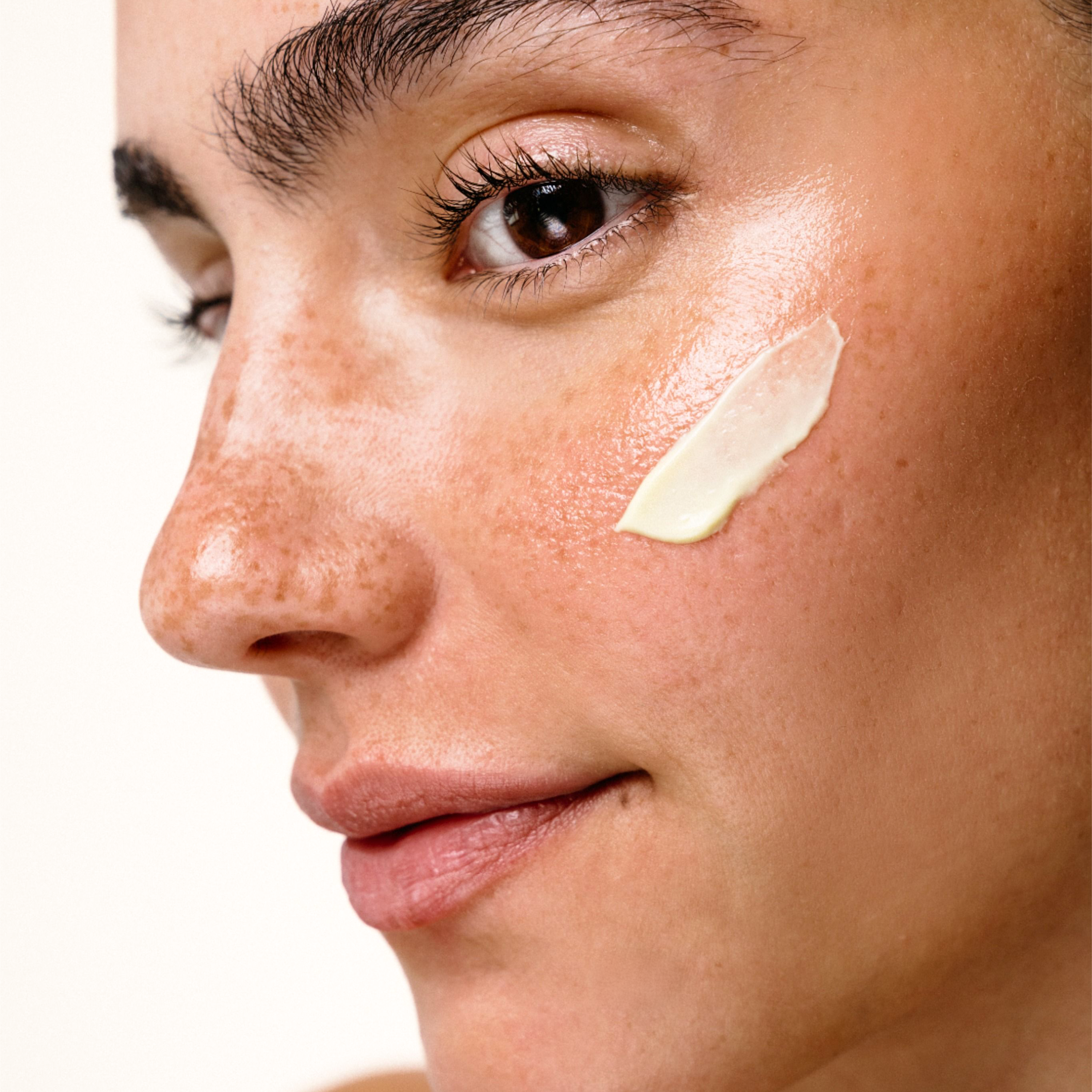 HERLOW Riche Cream applied on a model's cheek showcasing the pro-aging face cream benefits